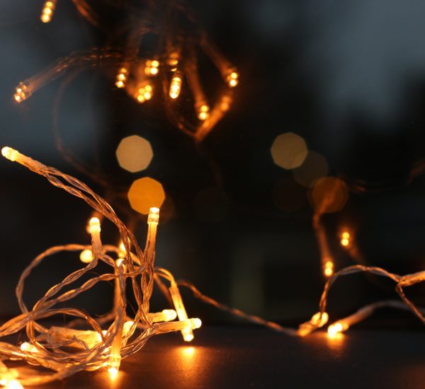 Zu sehen ist eine Girlande ( Lichterkette) die angeschaltet und zusammengelegt auf dem Boden liegt.