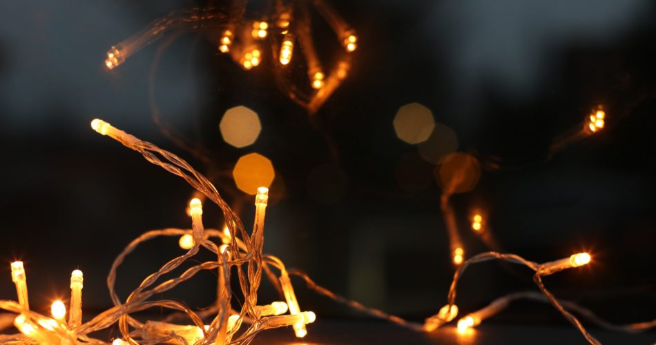 Zu sehen ist eine Girlande ( Lichterkette) die angeschaltet und zusammengelegt auf dem Boden liegt.
