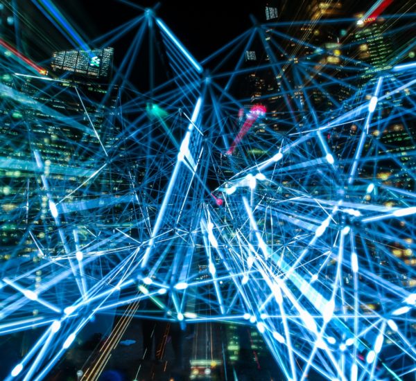 Zu sehen ist eine riesige blaue Verdrahtung (die ein Leuchtsystem darstellen soll) in einer Großstadt.