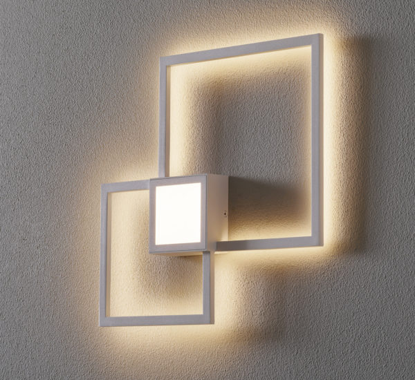 Zu sehen ist eine weiße Wandleuchte mit einem Quadrat in der Mitte wo sich die Leuchte befindet und 2 l-förmige Formen die sich oben recht und unten links befinden.